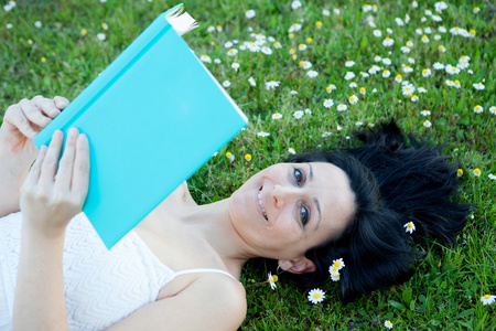 该名女子躺在读一本书花草甸