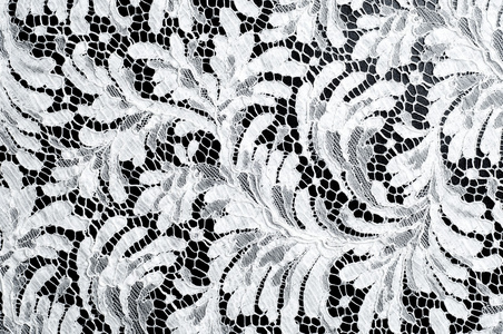 蕾丝面料质感..黑色背景工作室上的花边。由纱线或线制成的薄织物。通常是棉花或丝绸，一种，用圈线捻线或编织线做成