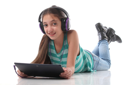 美丽的青少年女孩在地板上，使用一台平板电脑