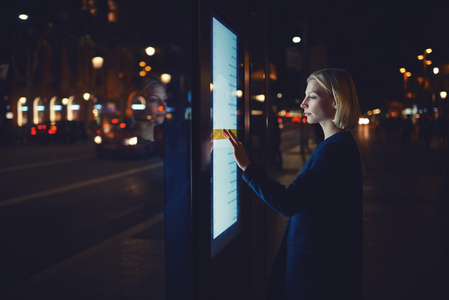 女人使用现代应用程序的公共汽车站