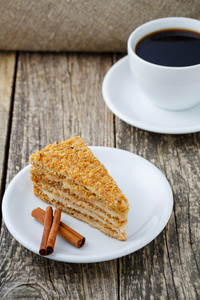 美味的蜂蜜蛋糕杯咖啡上木制背景