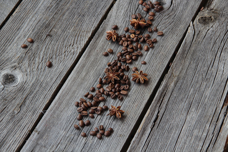 颗粒的黑咖啡和茴香星号上木制的背景