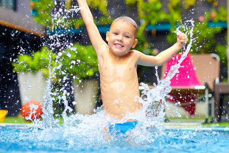 兴奋快乐的孩子男孩跳在池中，水乐趣
