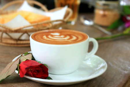 老式的拿铁艺术咖啡和红玫瑰