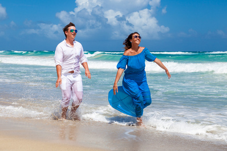 海滩情侣走在浪漫的旅行