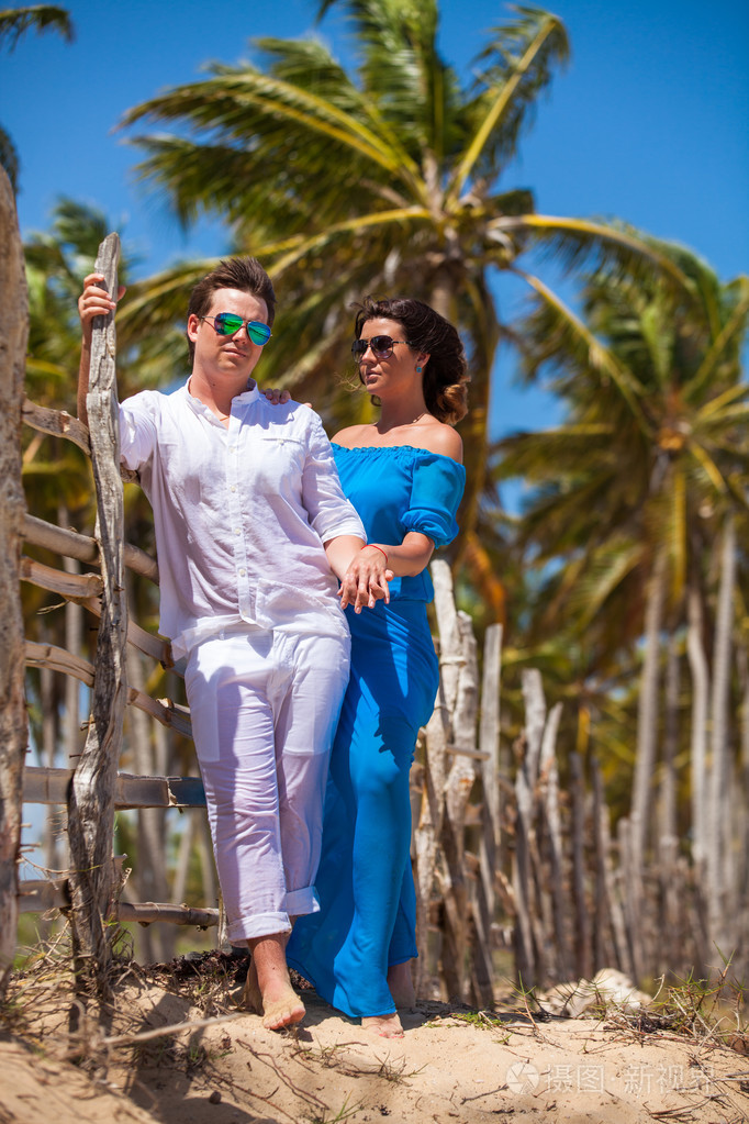 海滩情侣走在浪漫的旅行