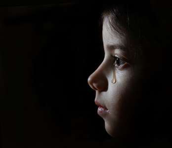 在黑暗中的女孩哭泣照片