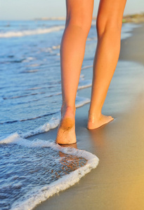 美丽的女人的腿，在沙滩上散步