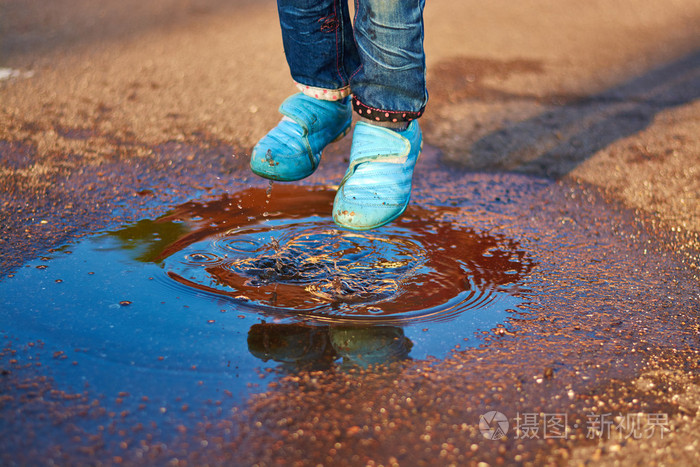 孩子在一个水坑里跳