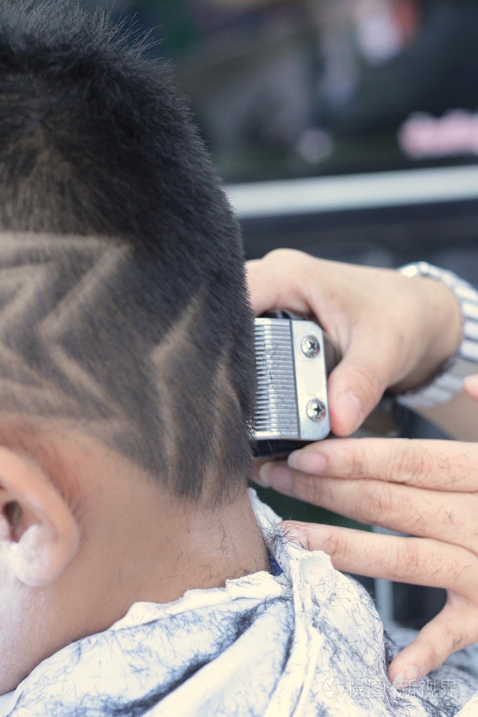 男孩的发型与帆船和剃刀在理发店