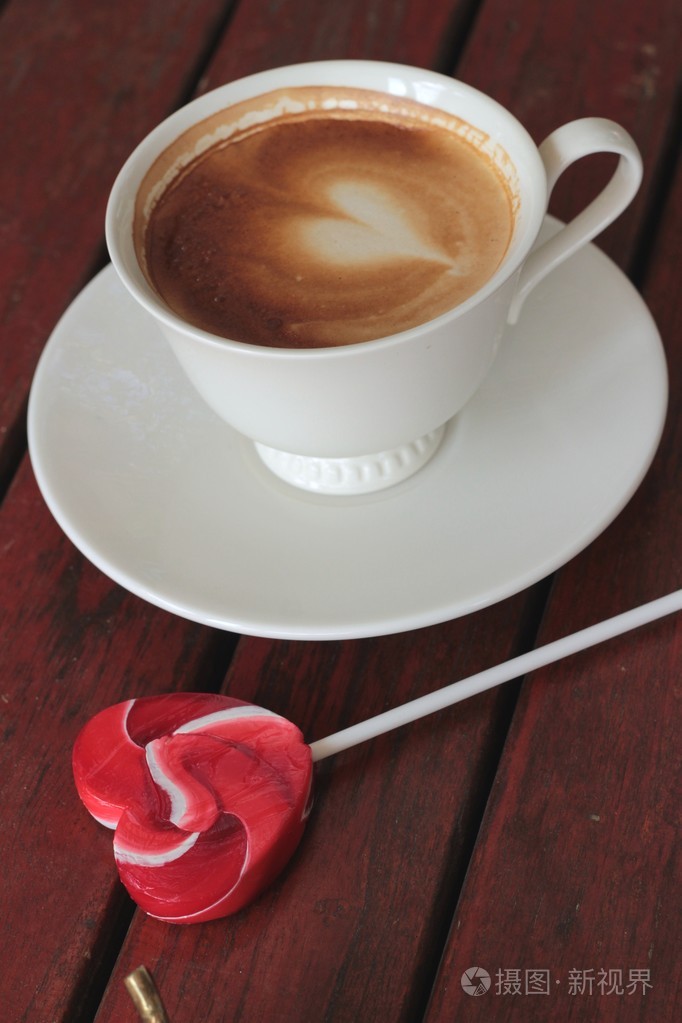 热拿铁咖啡在玻璃和糖果甜蜜情人节心