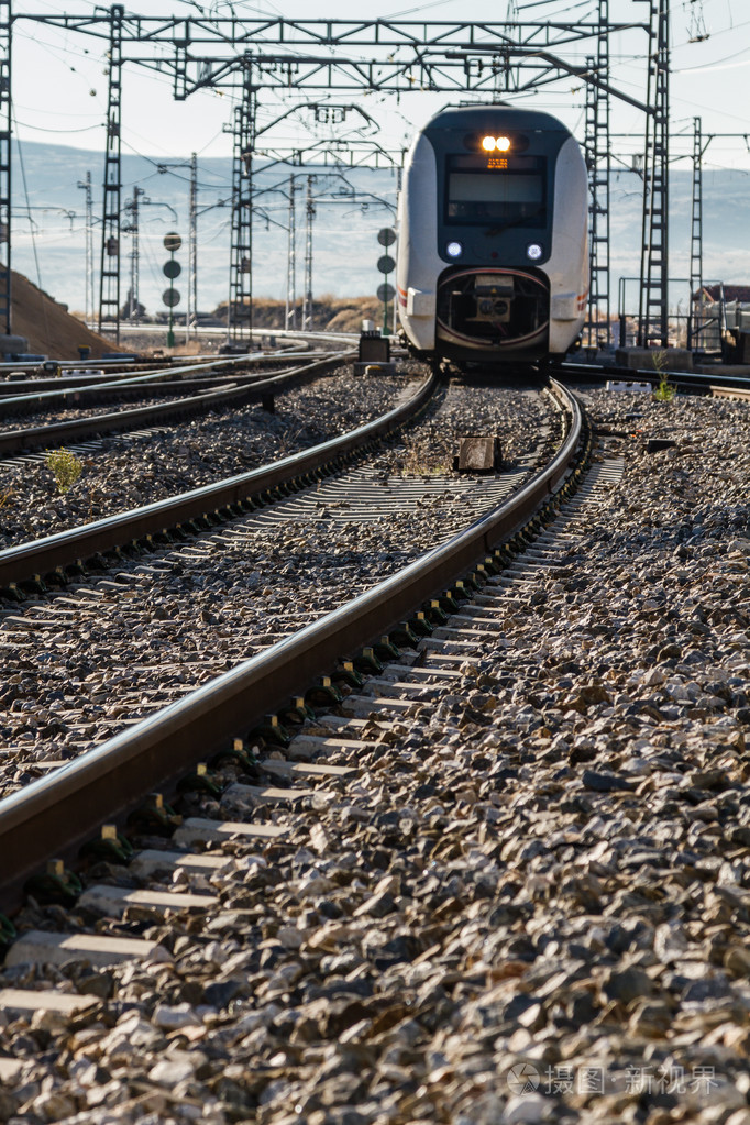 他们靠近火车在铁轨上的城市站