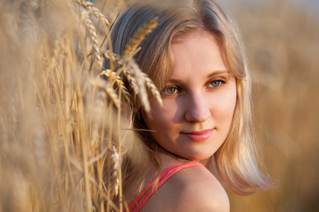 特写肖像年轻漂亮的女孩坐在干草中字段