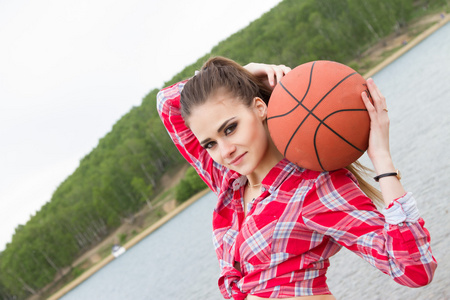 年轻漂亮的女孩,抱着一个篮球非洲女孩抱着篮球球戴手套的女孩抱着