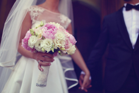 新娘抱着美丽的牡丹和玫瑰花束