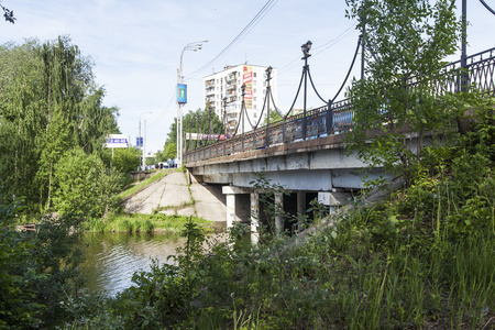 普希金诺，俄罗斯   在 2015 年 6 月 1 日。在阳光灿烂的夏天一天中的城市景观。通过谢列布良卡河桥