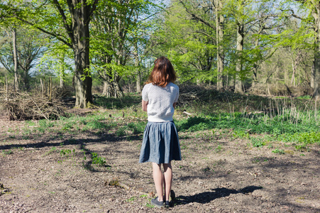 年轻女人站在一片森林