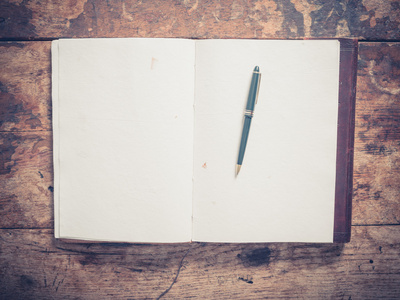 记事本和笔在一张小木桌上