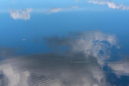 抽象的湖水的自然背景，天空的倒影，水上的云彩和美丽的小波浪