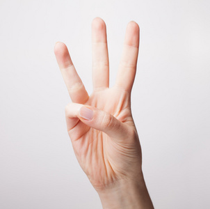 女手显示孤立在白色背景上的三根手指