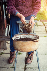 老妇人一壶装满泥土的清香。春天和清洁饮食概念的象征