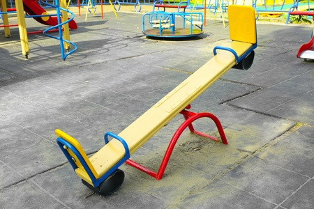 春天跷跷板灭菌器在操场上在公共公园的空跷跷板照片