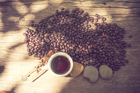 咖啡杯和咖啡豆在木桌复古色调
