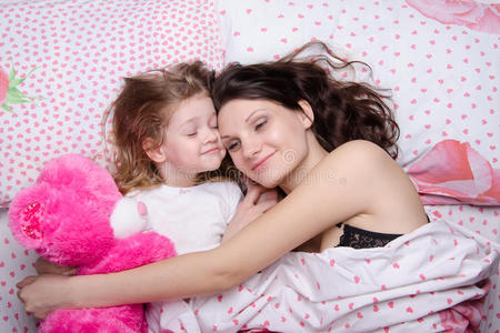 妈妈和女儿高兴地躺在床上休息