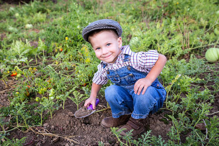 小男孩在花园里挖土
