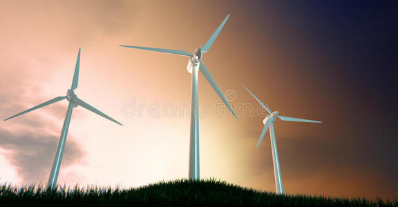 晨曦中草山上的风力涡轮机