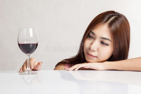 美丽的亚洲女人高兴地看着红酒