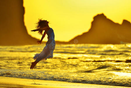 夏日夕阳下海滩上的年轻女子