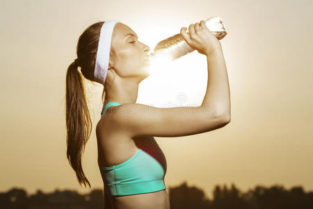 漂亮的女运动员正在喝瓶子里的纯净水