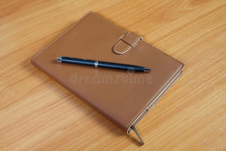木制棕色笔记本和钢笔