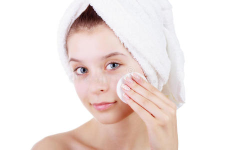 漂亮的年轻女子在洗完澡后用毛巾将脸上的皮肤擦在白色的背景上。