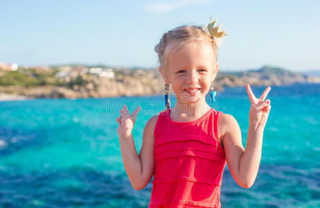 可爱的小女孩在热带海滩玩得开心