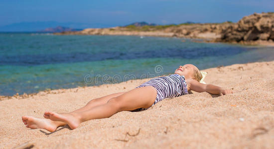 可爱的小女孩在热带海滩玩得开心