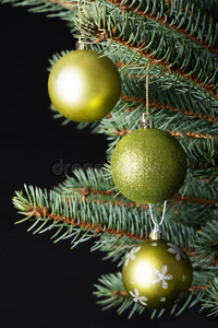 三个圣诞球挂在树枝上。