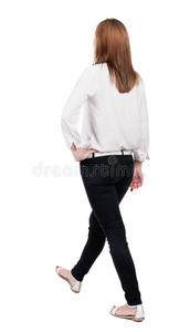 穿着牛仔裤行走的女人的后视图。美丽的金发女孩在m