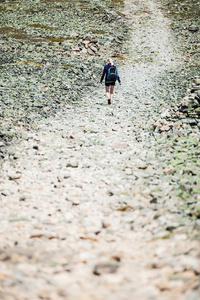 一个女人走在岩石的徒步小路上