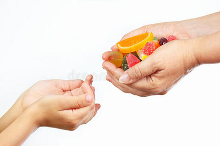 母亲的手给孩子们五颜六色的糖果和果冻