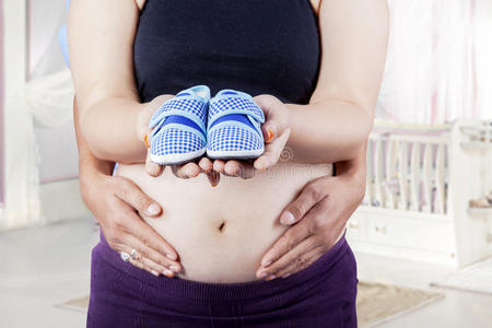 怀孕的肚子和婴儿鞋