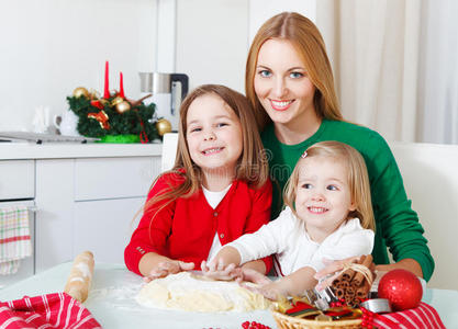 两个可爱的女孩和妈妈在英国烤圣诞饼干
