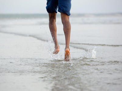 赤脚在海边的水中奔跑
