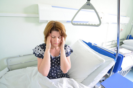 女性患者头痛在医院病房的床上