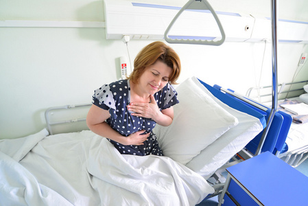 女性患者发自内心痛苦躺在医院病房的床上照片