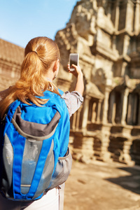 女游客与智能手机拍照在吴哥寺