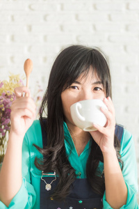 美丽年轻的亚裔女子和杯咖啡