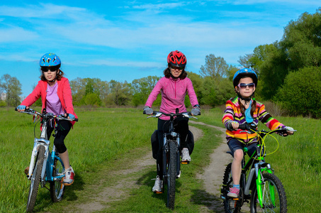 幸福的母亲和孩子骑自行车，自行车户外，活跃的家庭运动