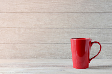木制的桌子上的红色咖啡杯